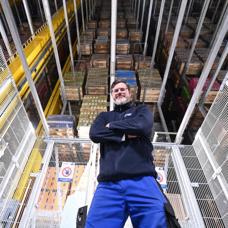 Ein Mitarbeiter steht vor einem großen Lager