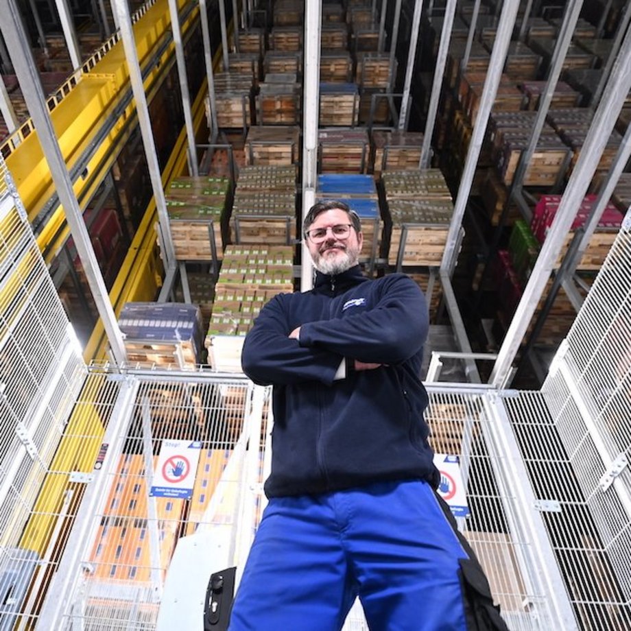 Ein Mitarbeiter steht vor einem großen Lager